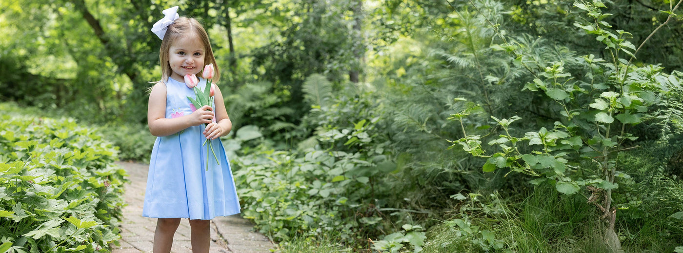 young girl in sweet blue dress with tulips