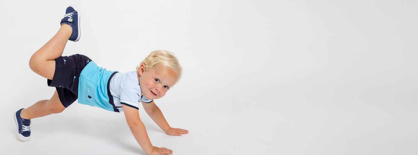 boy with hands on floor and foot in the air