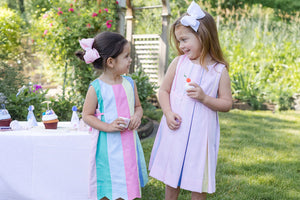 two girls in dresses having a tea party